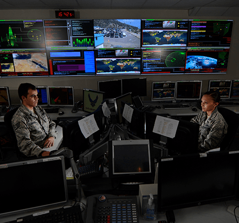 Two United States military soldiers using computers in an intel computer room