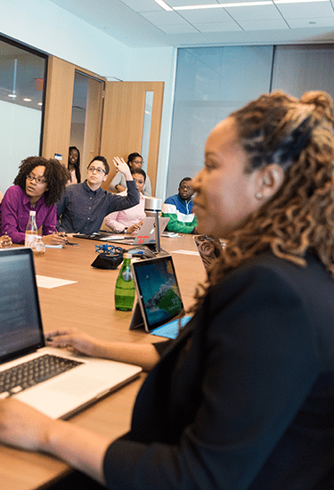 A group of people around a desk receiving digital signage software training